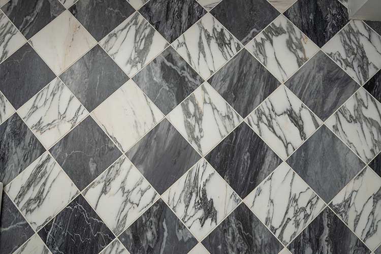 Detail view of the classic black and white marble checkerboard flooring installed in the grand foyer.