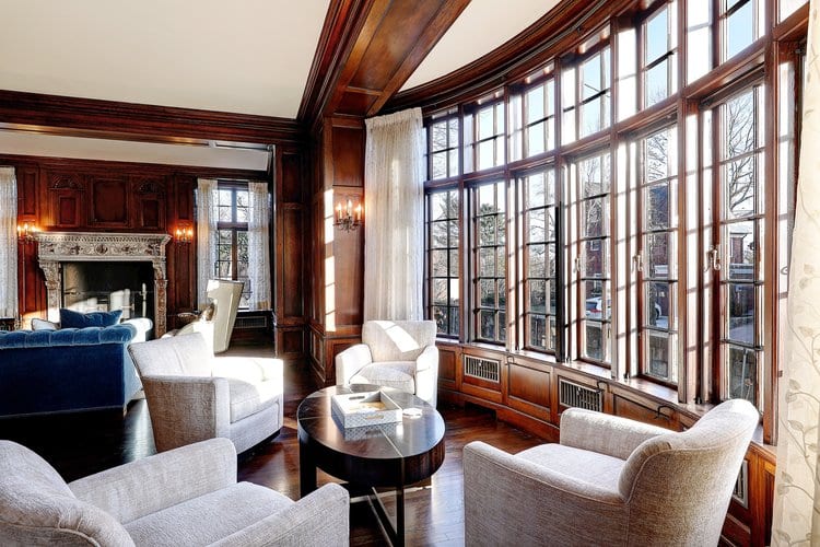 Formal living room renovation preserving the original curved window bay and intricate wood paneling of the Cherry-Hallworth House.