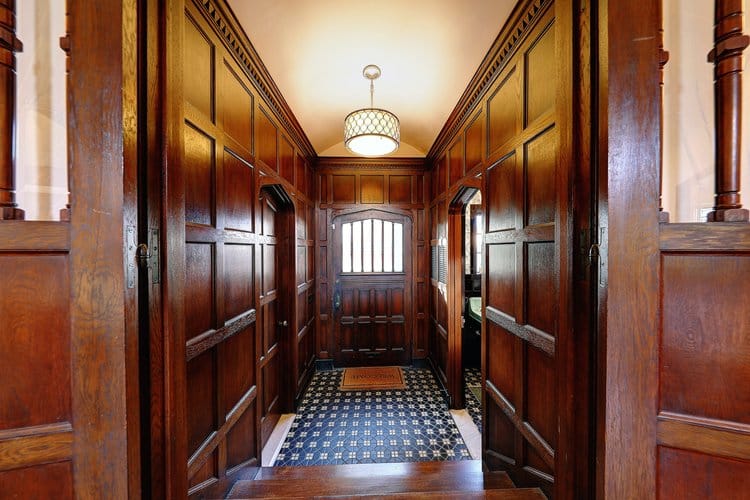 Grand entryway renovation featuring restored original judge's paneling and historic millwork in a luxury Providence home.