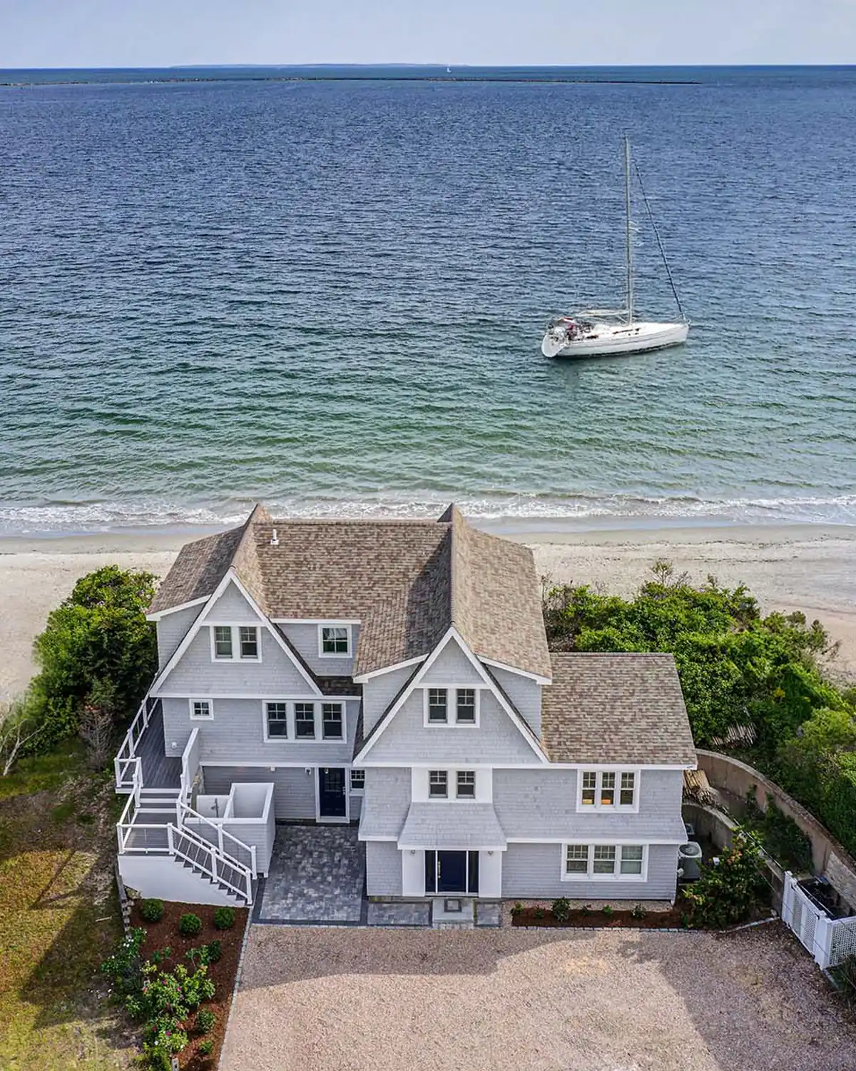 Aerial view of a luxury waterfront home renovation in Narragansett, RI, overlooking Sand Hill Cove.