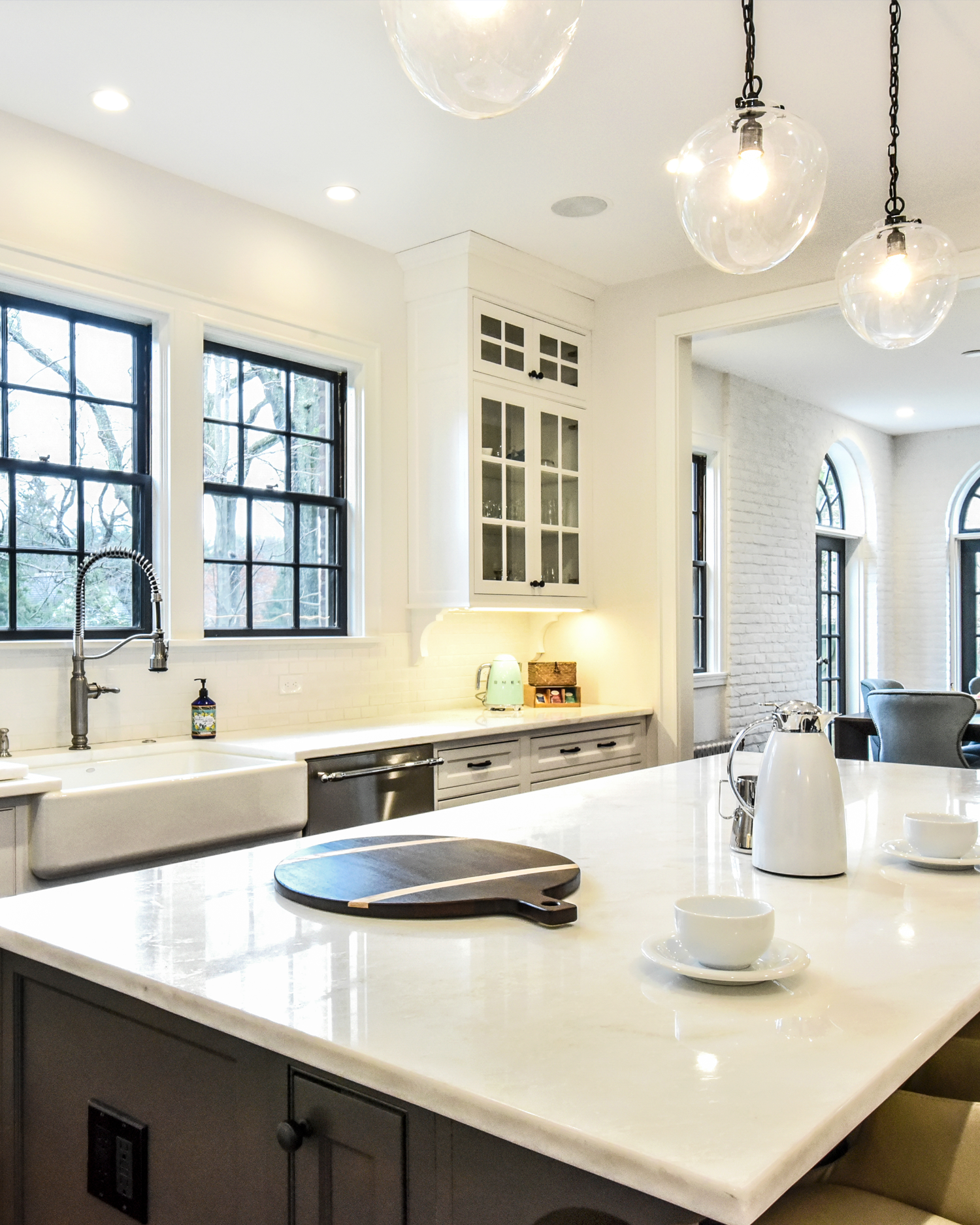 Detail of luxury marble countertops and pendant lighting in a newly renovated chef's kitchen.