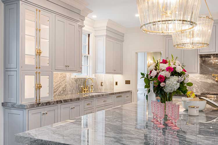 Detail of the thick marble kitchen island slab and crystal pendant lighting in a historic Providence home.