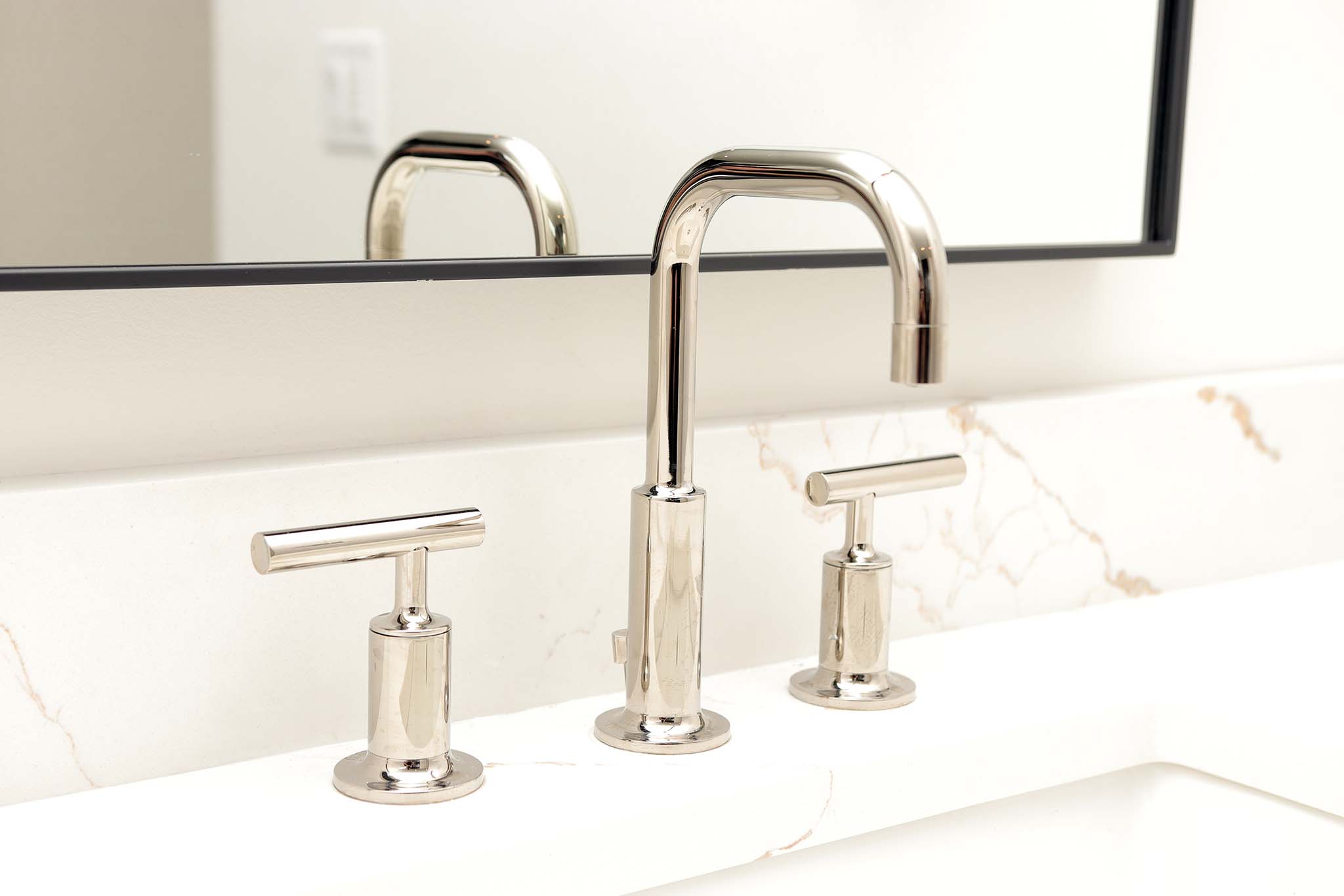 Minimalist bathroom faucet detail, reflecting the contemporary but timeless aesthetic of the home.
