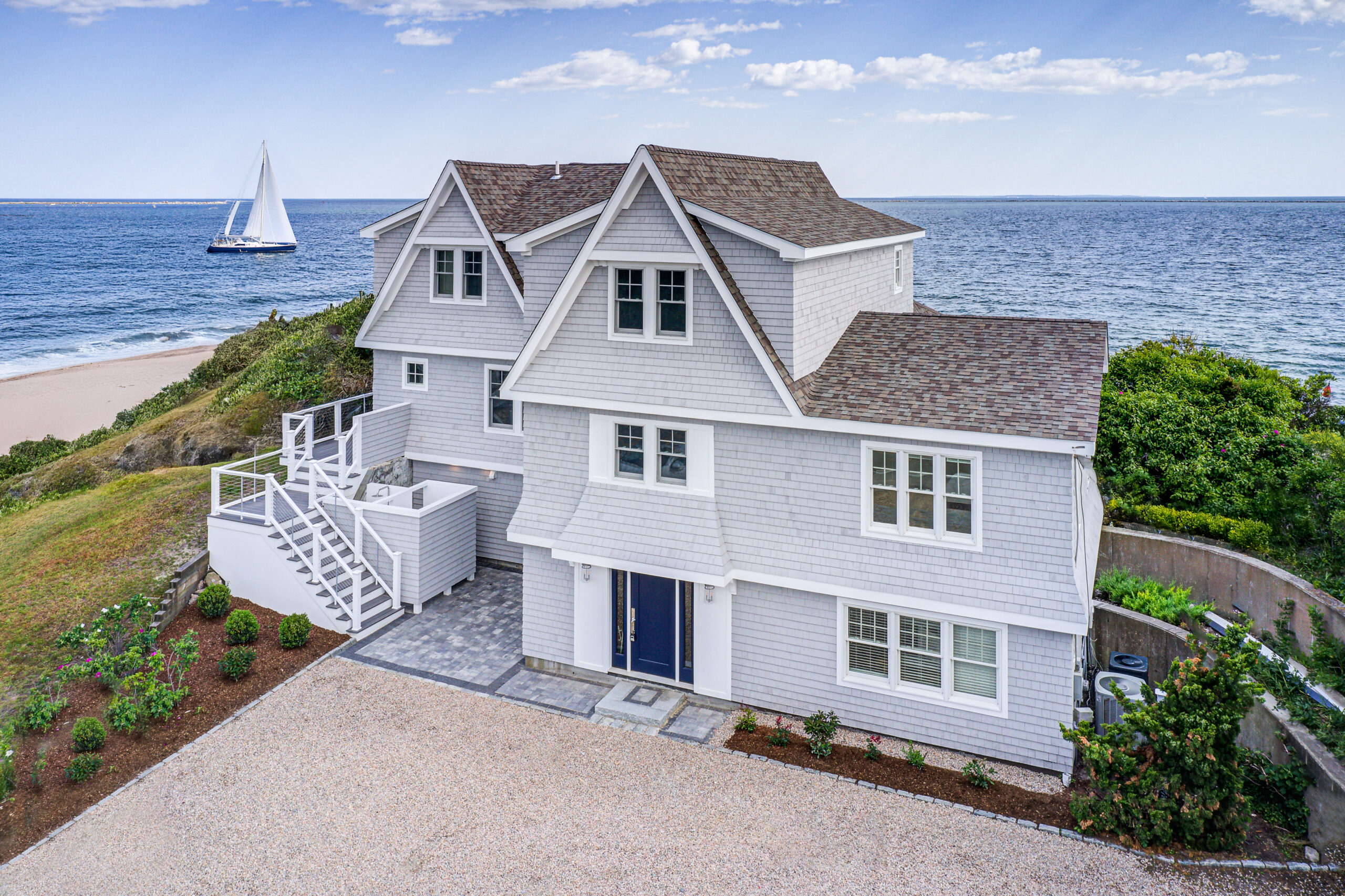 Aerial view of a luxury waterfront home renovation in Narragansett, RI, overlooking Sand Hill Cove.