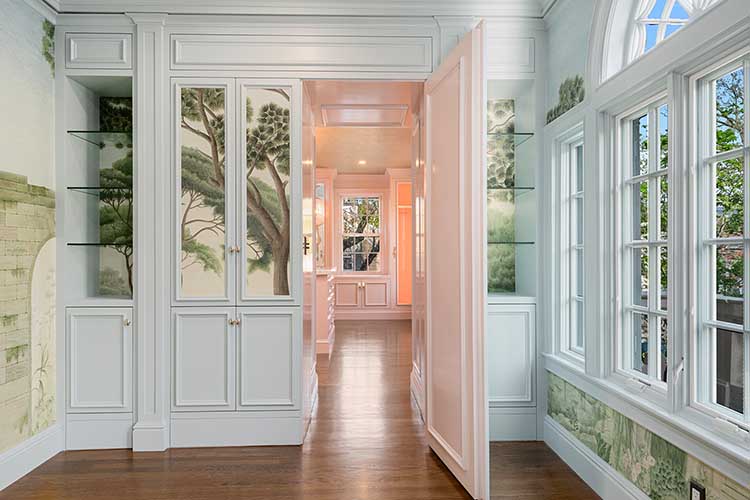 A custom secret bookcase door swings open to reveal a private luxury suite, a highlight of this Providence historic renovation.