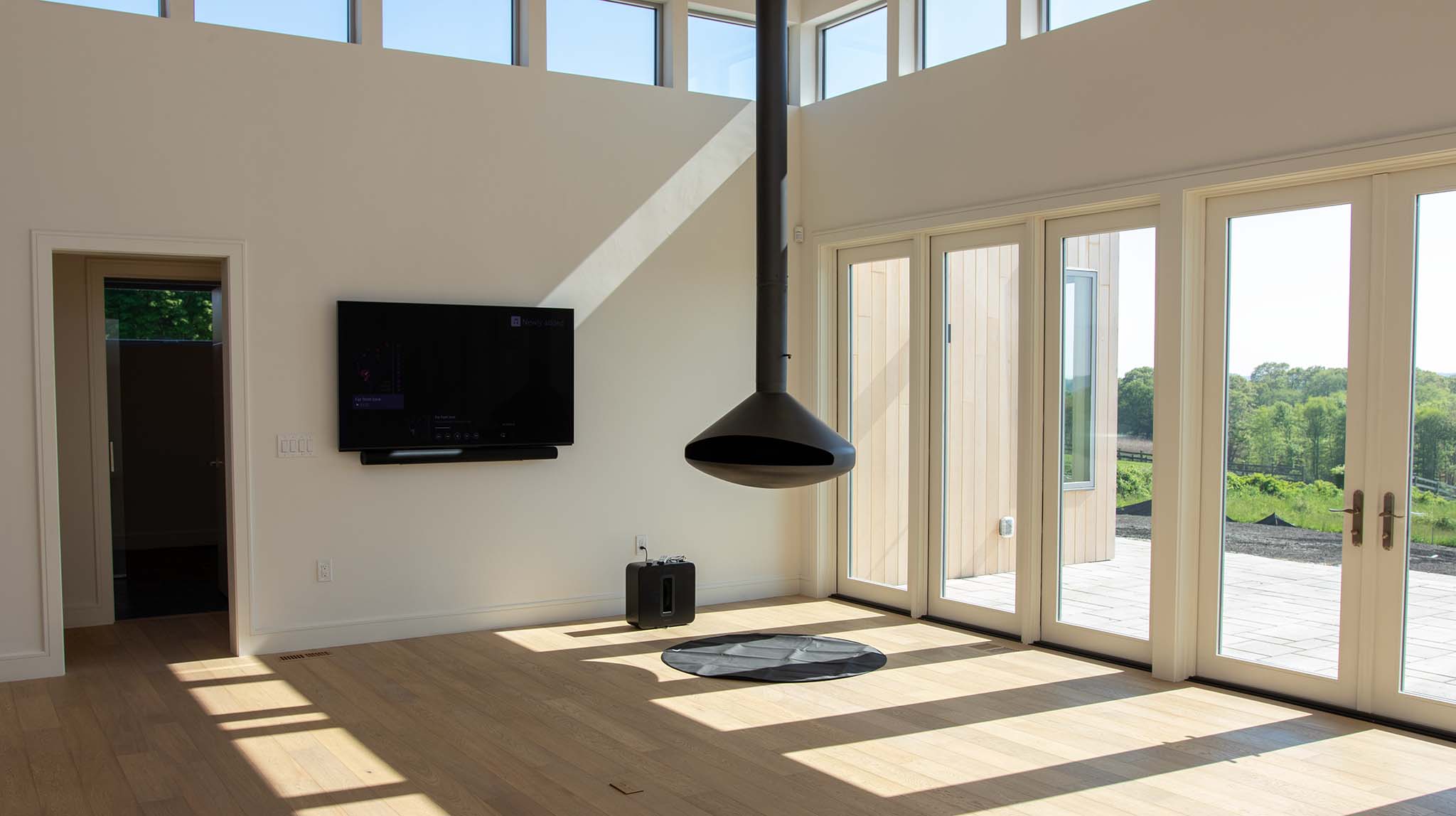 Modern living area with expansive glass doors that blend the interior space into the Sakonnet River landscape.
