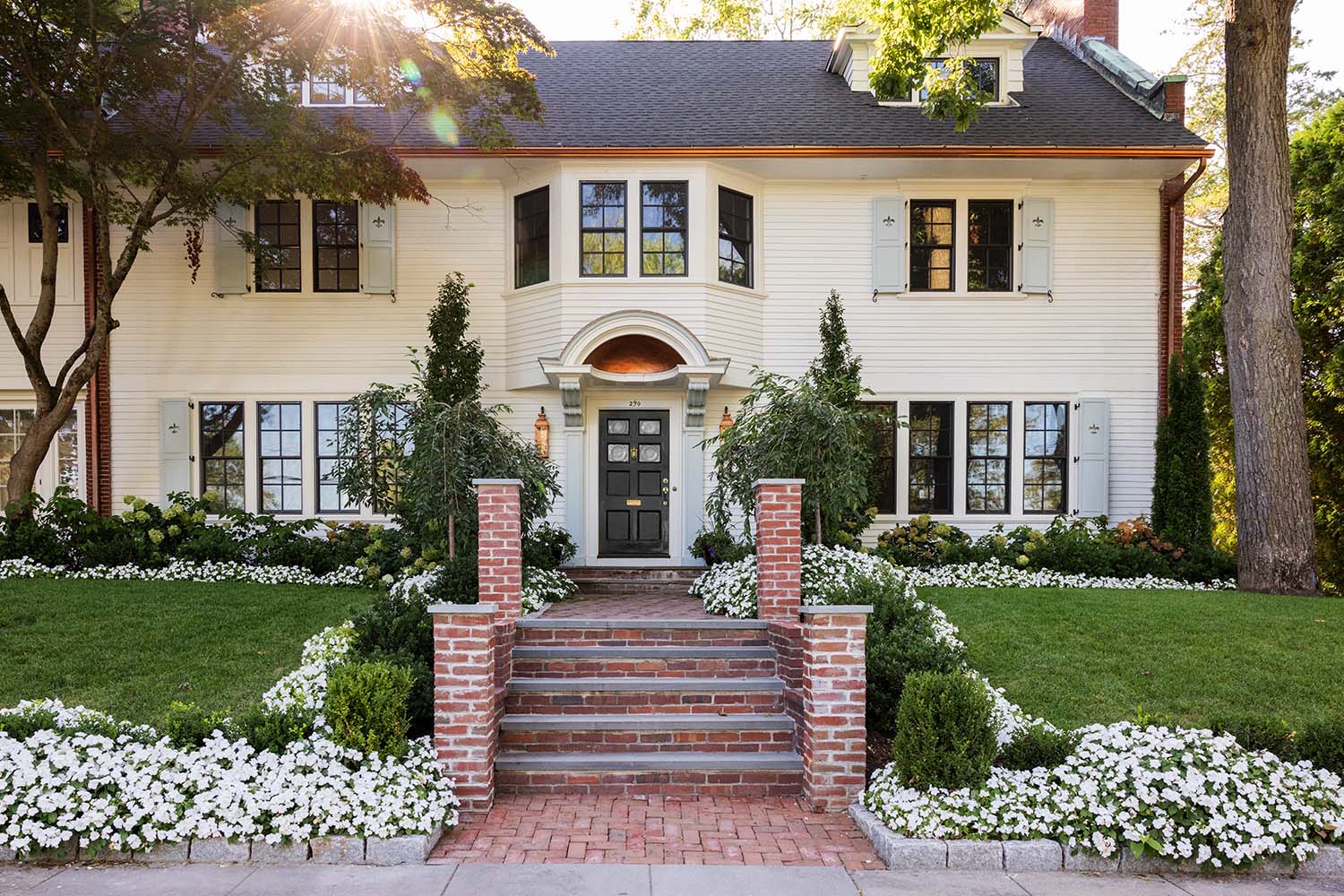 Closer view of the symmetrical front facade and inviting brick walkway.
