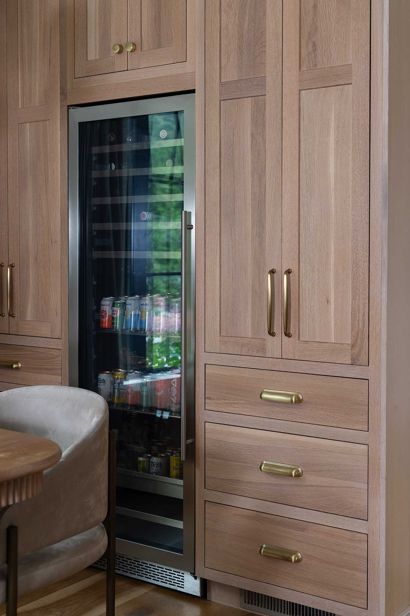 Butler's pantry and wet bar area featuring wire-brushed wood cabinetry and a beverage fridge.