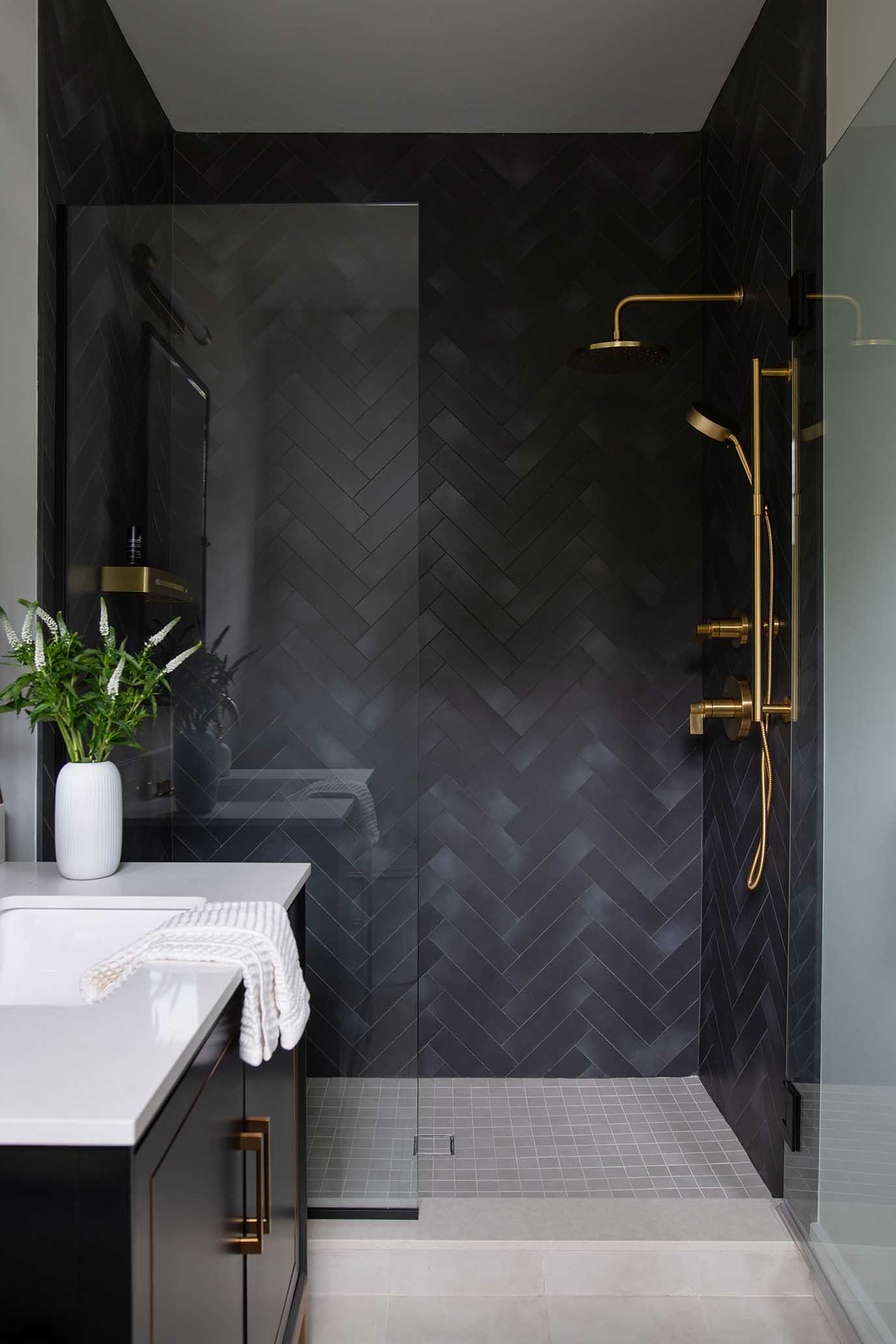 Luxury walk-in shower featuring vertically stacked tile and unlacquered brass fixtures.