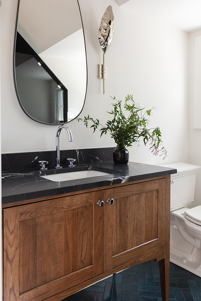 Sophisticated guest bathroom with a wood vanity and black soapstone countertop.