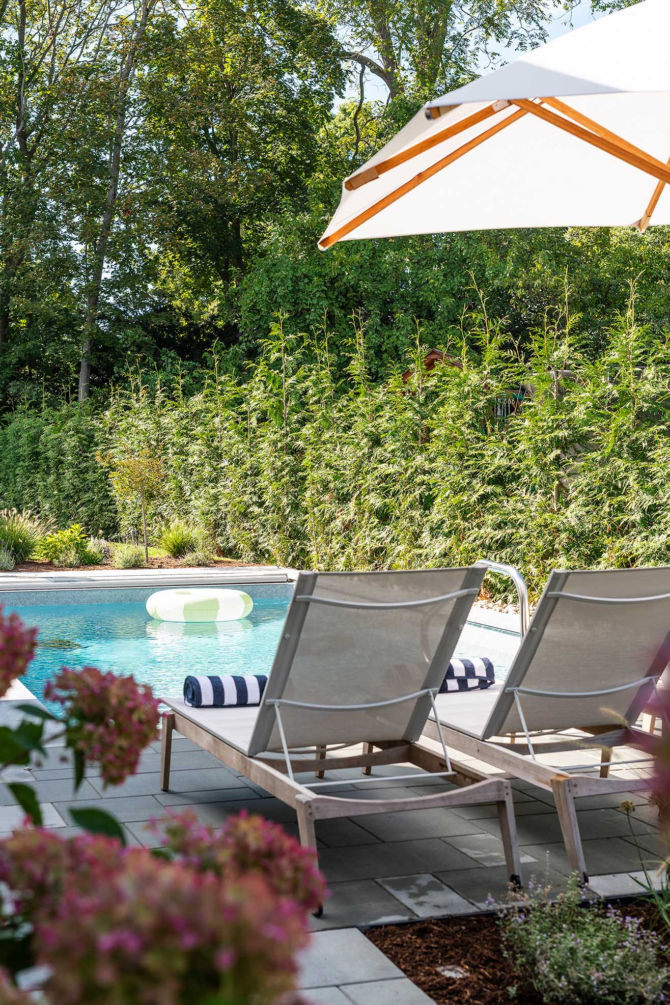 In-ground pool and patio area, a staple of luxury new home builders in Rhode Island, blending modern leisure with historic district aesthetics.
