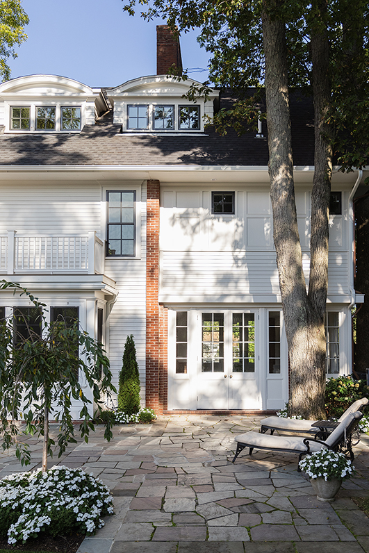Wide shot of the rear patio and garden, a private oasis in the city.