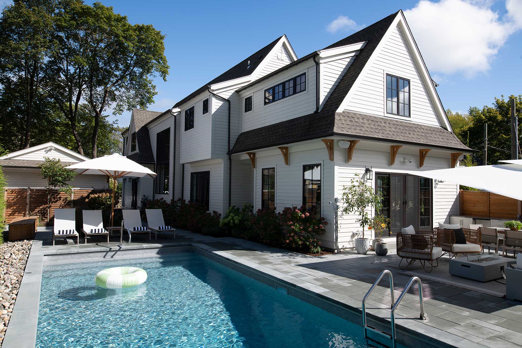 Rear view of the home showing the seamless connection between the pool area and the main house architecture.