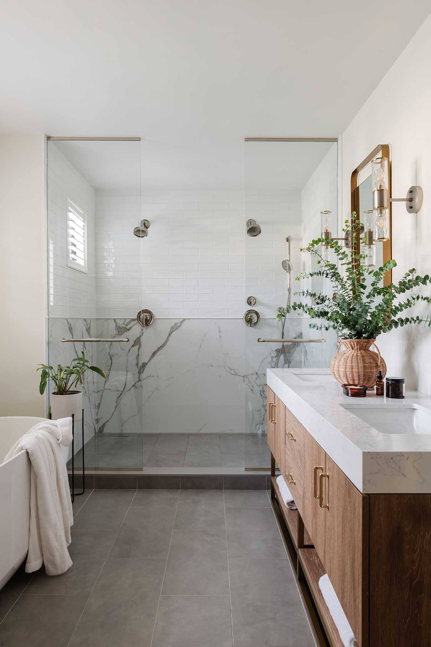Spacious master bathroom featuring a glass-enclosed shower and dual wood vanity, creating a spa-like retreat in a RI home.