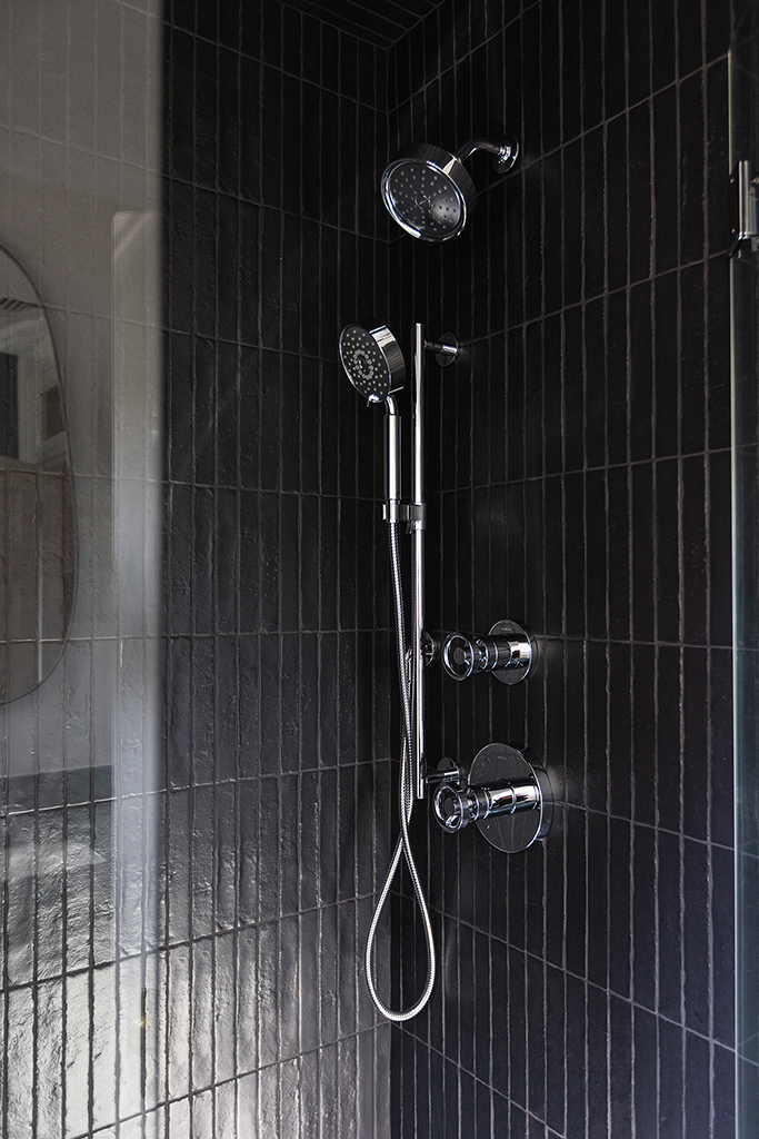 Striking modern shower design featuring vertical black subway tile.