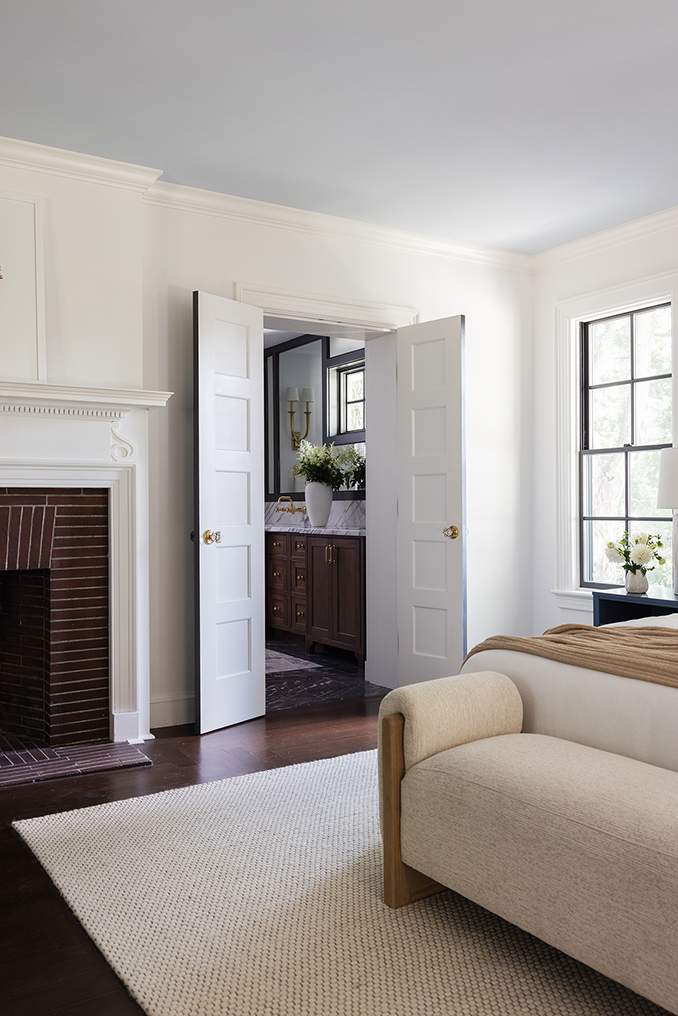 Serene primary bedroom suite featuring a restored original brick fireplace.