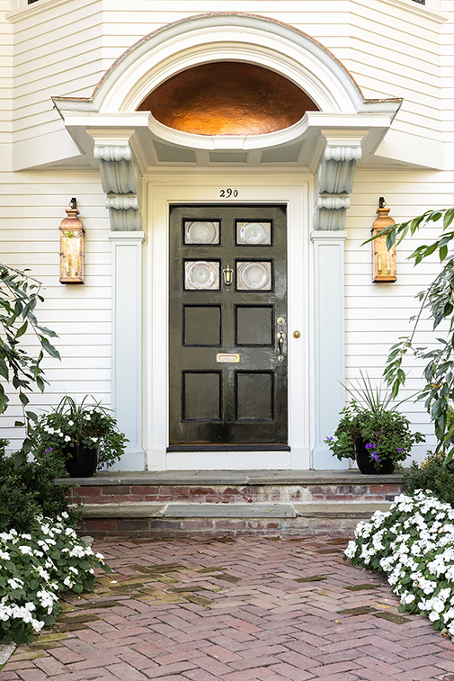 Detail of the grand black front door and copper-roofed portico.