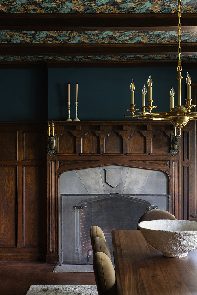 Formal dining room featuring fully restored original wood paneling and a historic fireplace.