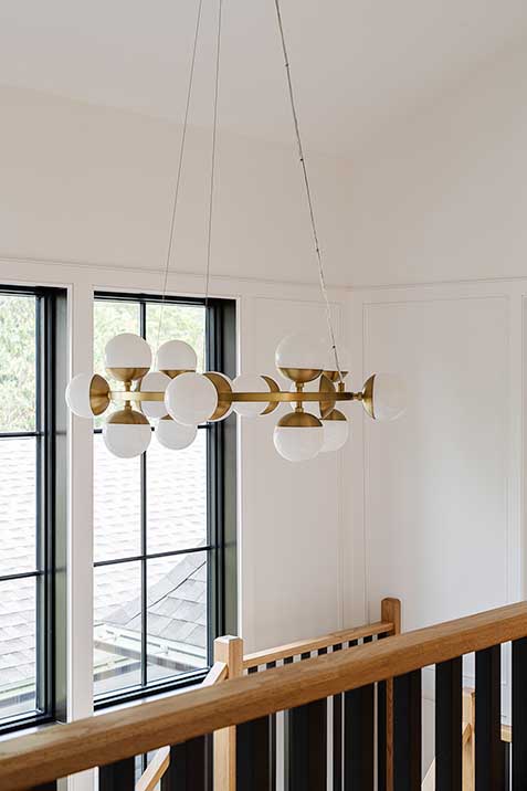 Modern gold chandelier drawing the eye upward to the high ceilings of this custom East Greenwich home.