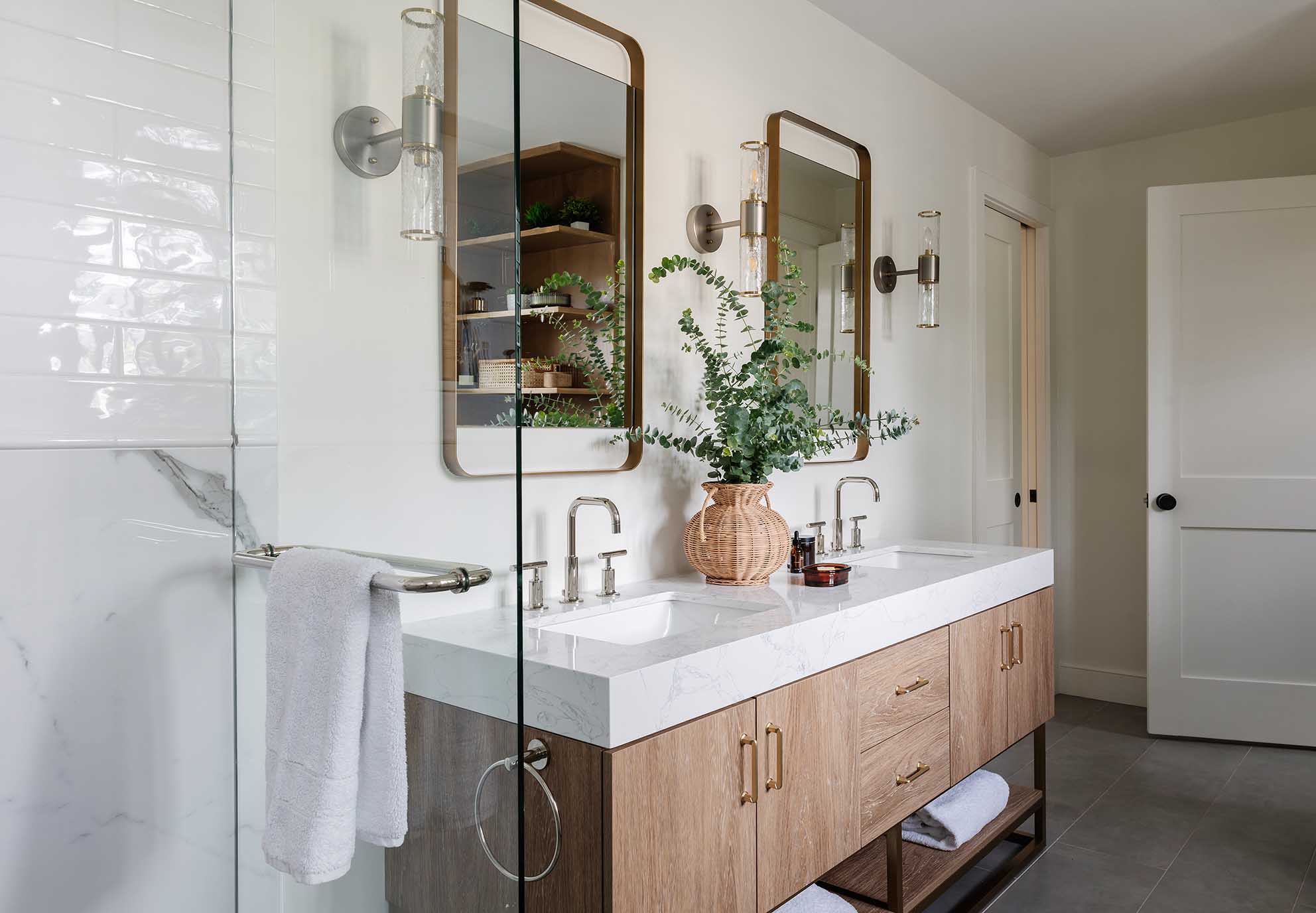 Detail shot of a custom white oak floating vanity with dual mirrors in a luxury Rhode Island bathroom.