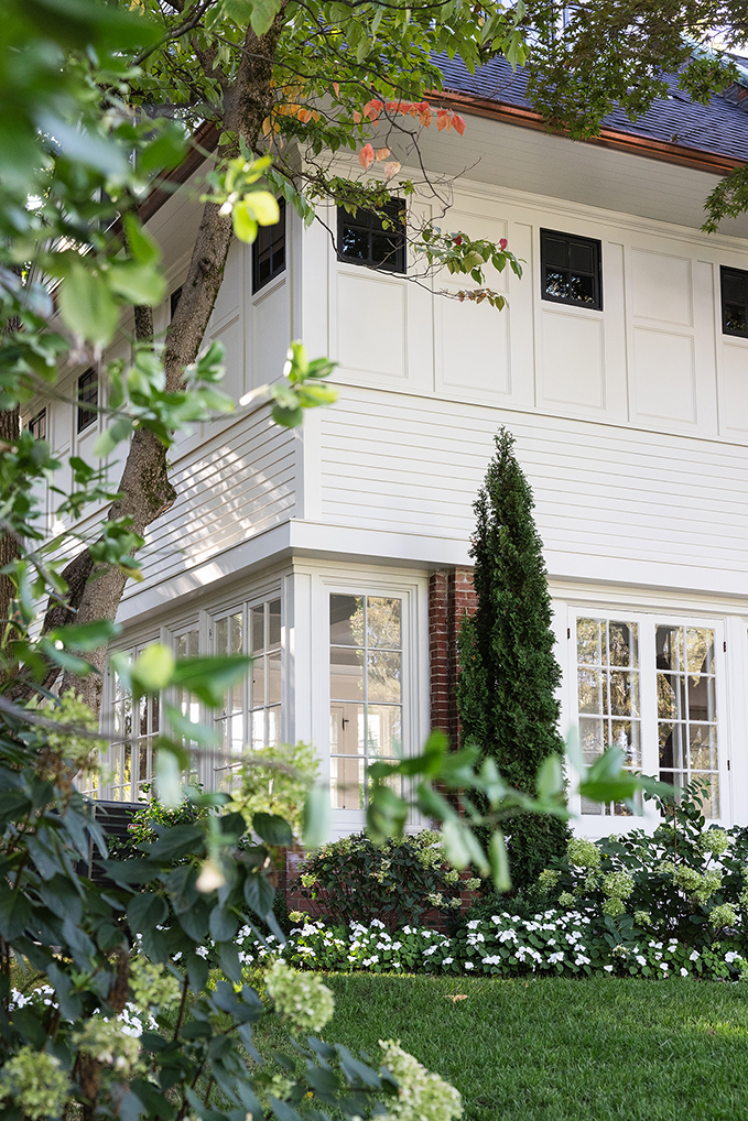 Rear exterior view highlighting the clean white stucco and black window frames.